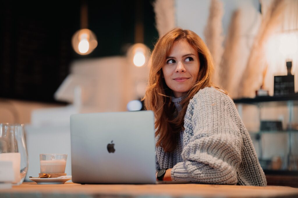 Writer of website copy on computer in cafe | North Branch Copywriting Co. 