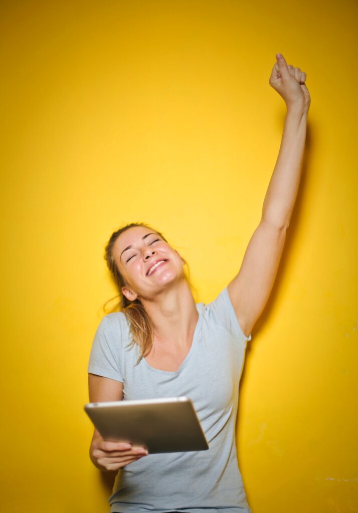 Woman with arm raised in "Yes!" motion after saying yes to an offer pitched through email sequences | North Branch Copywriting Co. 