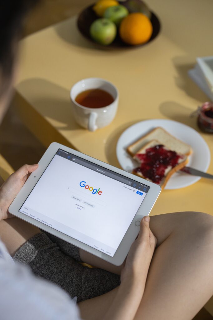 Person in socks with toast and jelly interacting with Google home page | North Branch Copywriting Co. 