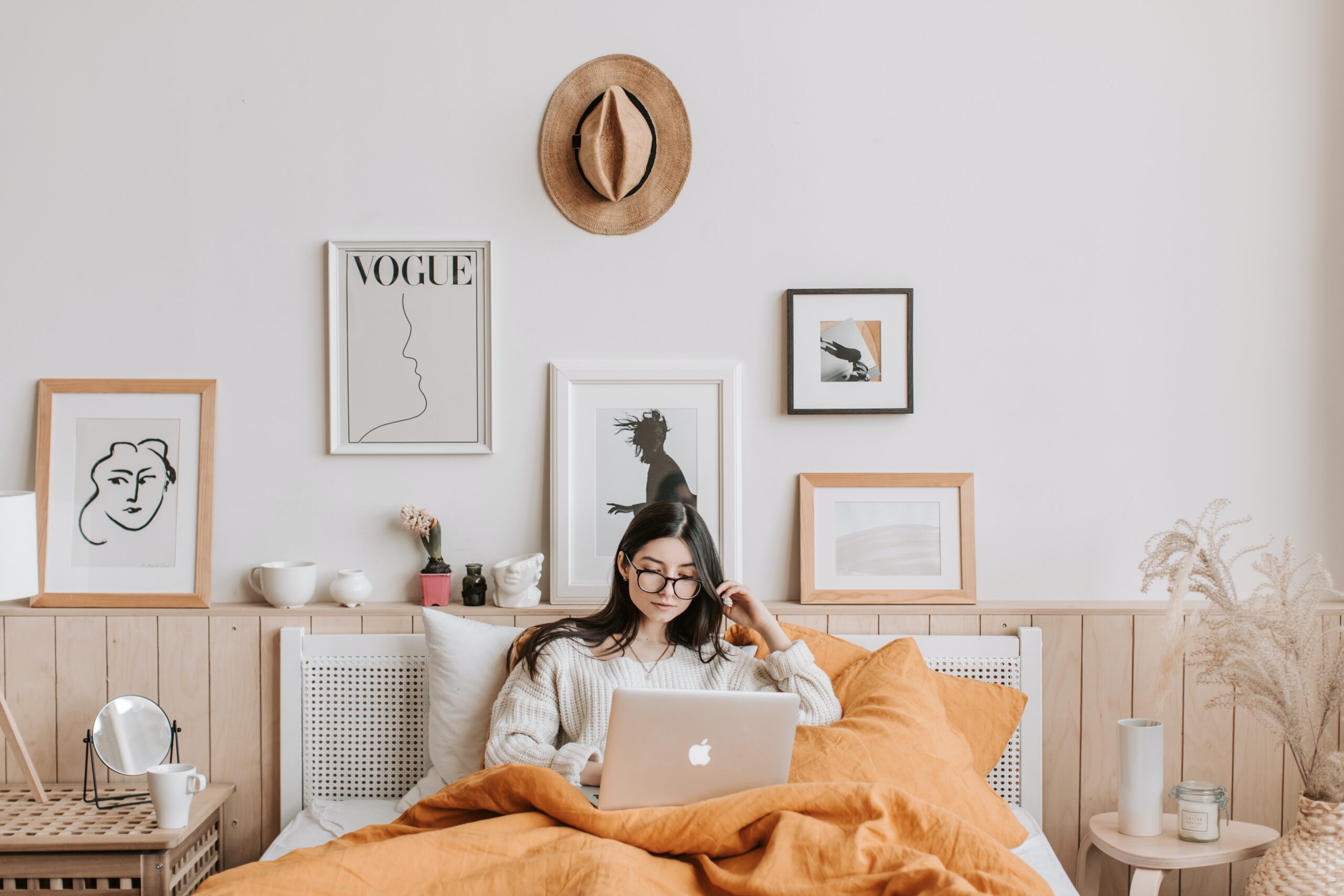 Woman in bed with laptop, looking at email welcome sequence | North Branch Copywriting Co.