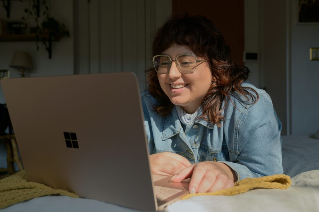 Woman smiling while clicking on a landing page example | North Branch Copywriting Co. 