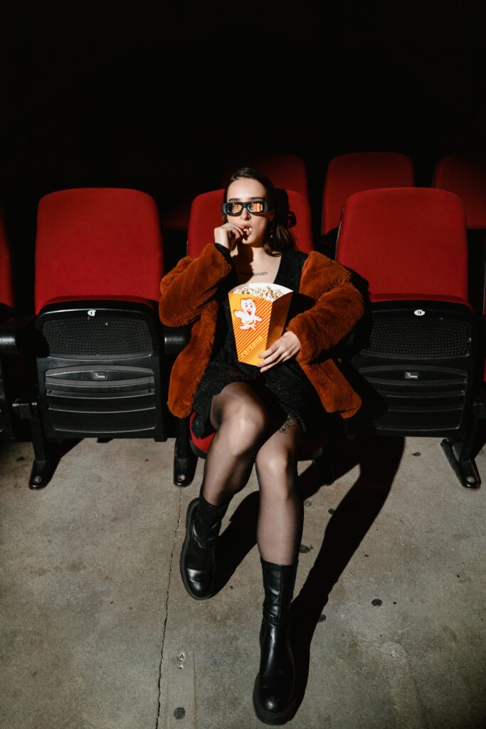 Woman sitting in movie theatre with popcorn | North Branch Copywriting Co. 