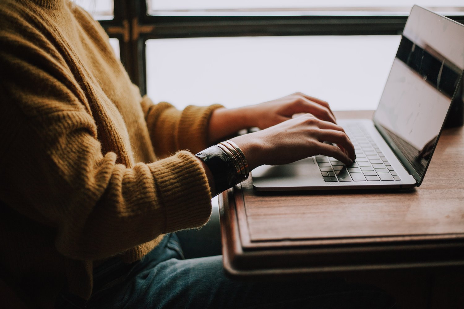 Close up of woman at laptop writing web copy | North Branch Copywriting Co.