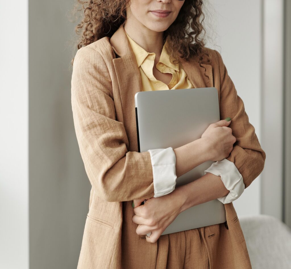 Entrepreneur holding a closed computer | North Branch Copywriting Studio